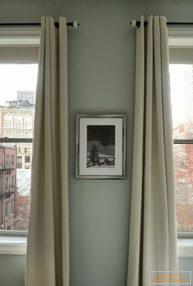 Interno di un piccolo appartamento: lunghe tende alle finestre
