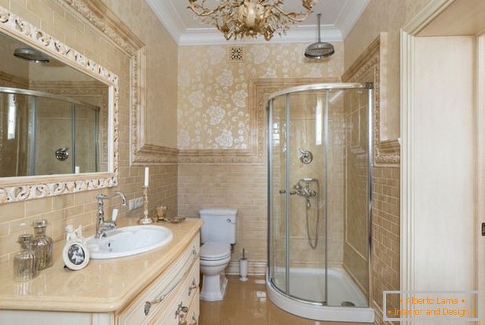 Il bagno è decorato in stile neoclassico. Un grande specchio, incorniciato da una cornice ampia, rende l'immagine completa.