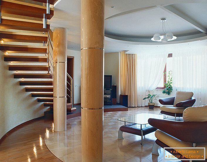 Un ampio e luminoso soggiorno sotto una scala in un appartamento su due livelli. 