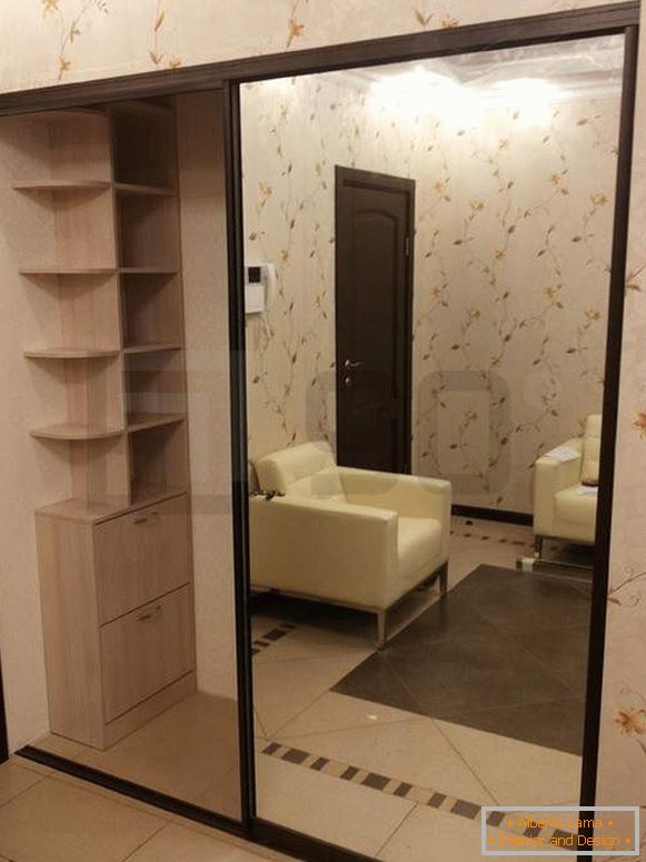 Scompartimento dell'armadio incorporato con le porte dello specchio nell'interno del corridoio