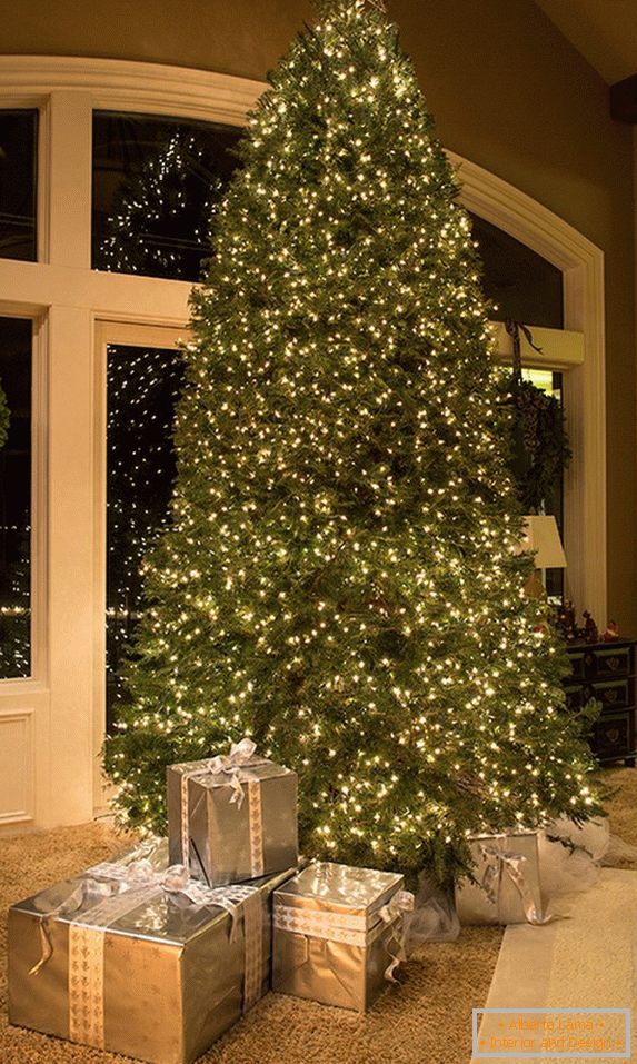 Decorazione insolita di un enorme albero di Natale con ghirlande