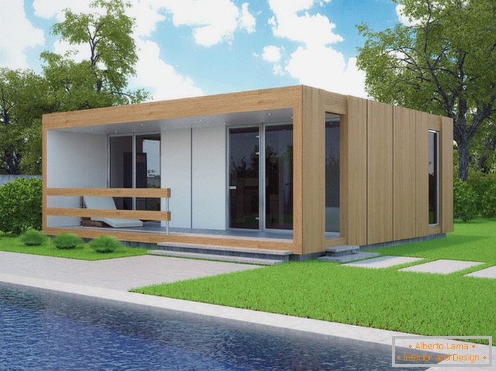Una piccola casa modulare con una piscina nel cortile. Il design elegante di una casa che viene costruita rapidamente sembra organicamente sullo sfondo di un prato corto tagliato.