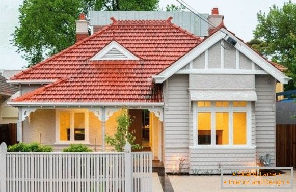 La facciata moderna di una casa privata è bianca con un tetto rosso