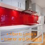 Mobili bianchi e un grembiule rosso all'interno della cucina