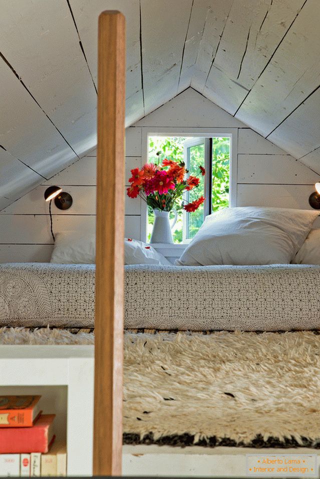 Camera da letto sotto il soffitto in una piccola casa accogliente