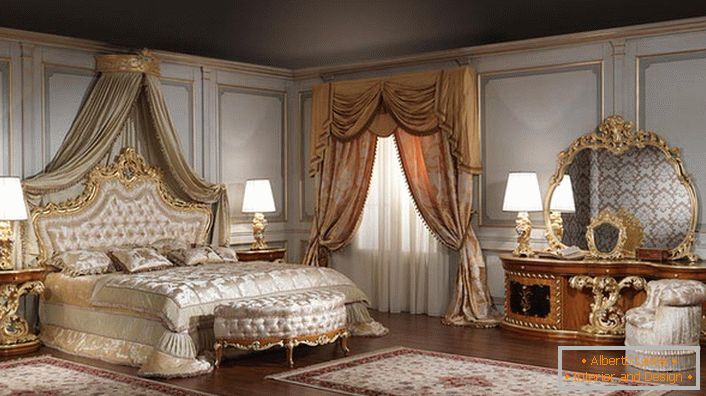 Specchio per una grande camera da letto è scelto correttamente. La forma dell'ovale sbagliato sembra grande nella cornice di un legno dorato intagliato.