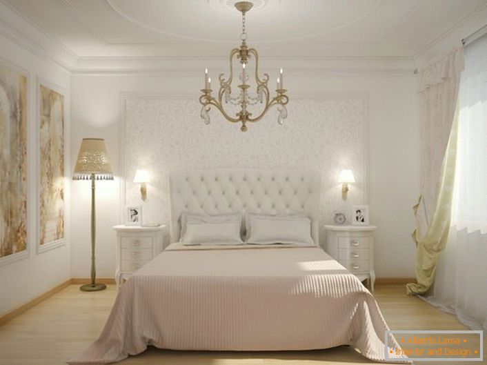 Al centro dell'interno della camera da letto c'è un letto con una testiera alta in tessuto imbottito. La morbida imbottitura trapuntata rende l'atmosfera nobile ed elegante.