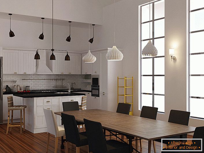 Un esempio di illuminazione ben selezionata per la cucina in stile scandinavo. Per illuminare le aree da pranzo e di lavoro, vengono utilizzati diversi modelli di lampadari a soffitto. 