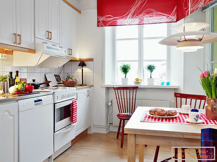 Il colore bianco in combinazione con il rosso nobile esalta visivamente la cucina. Gli accenti luminosi e saturi rendono la stanza elegante e creativa. 