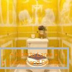 Mattonelle gialle con ornamento bianco nella toilette