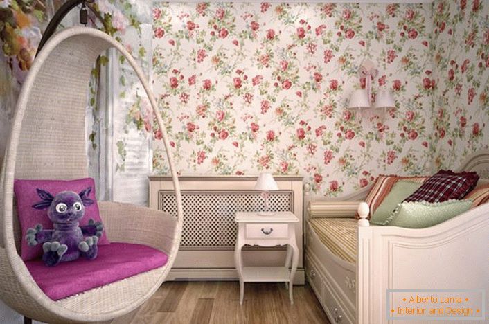 La stanza per una giovane donna è decorata in stile country. Nelle migliori tradizioni di stile, il designer ha utilizzato la carta da parati con un ornamento floreale.
