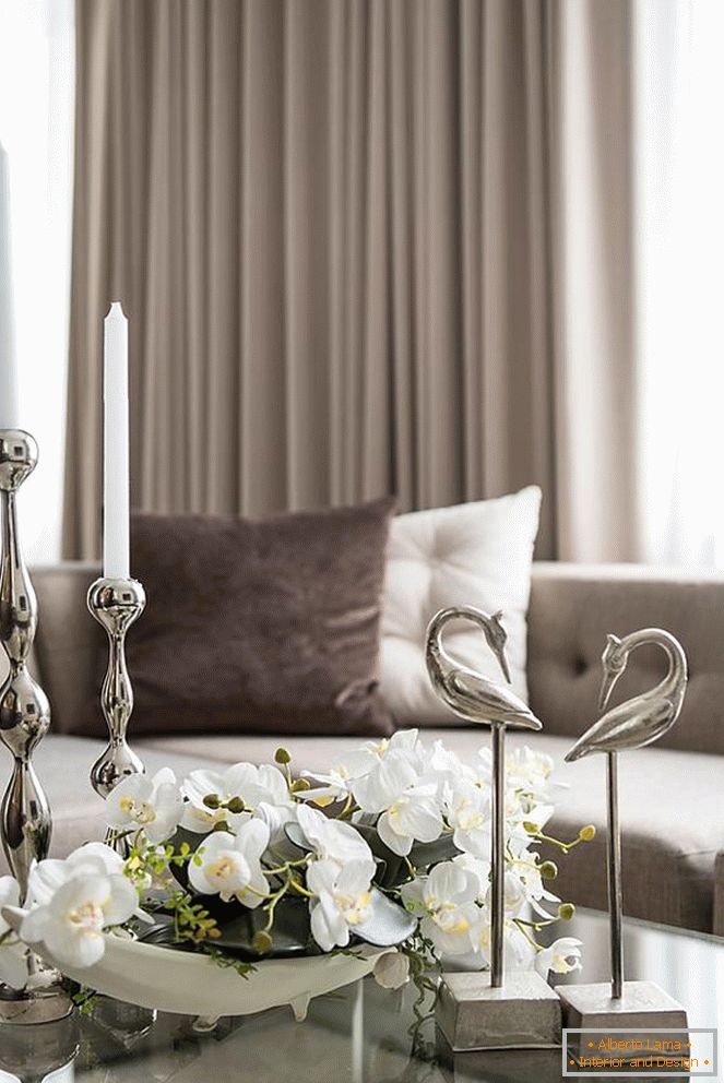 Composizione di orchidee, candele e altri elementi decorativi sul tavolo del soggiorno