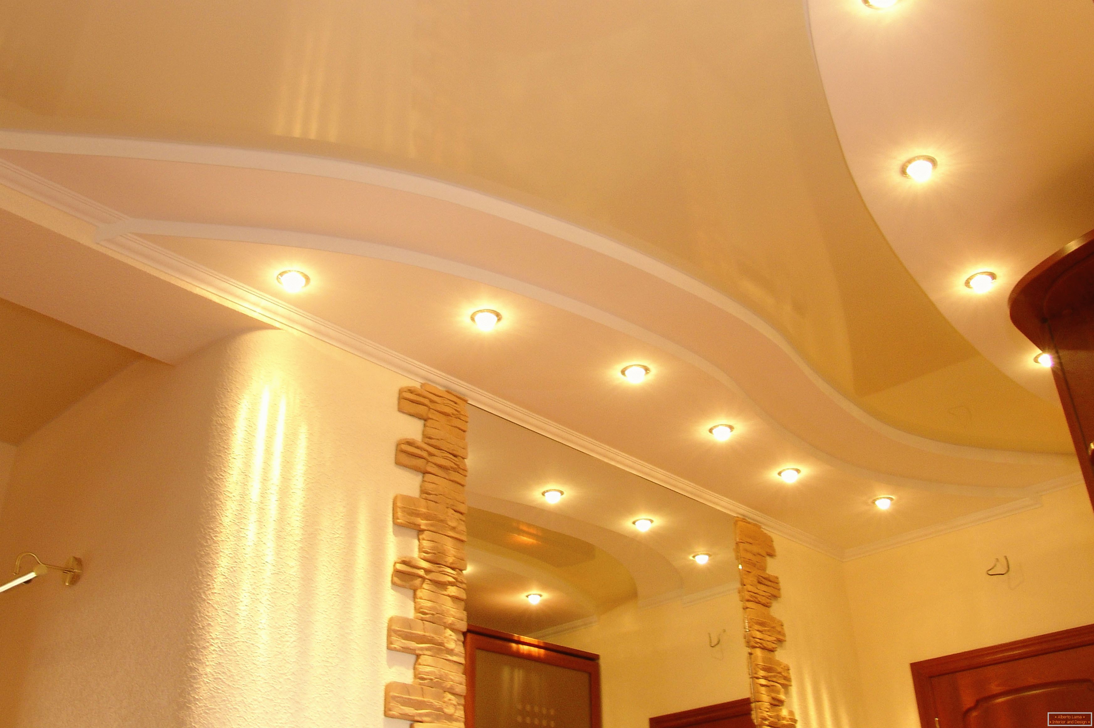 Soffitto decorato correttamente nel corridoio. Punto di illuminazione - l'opzione più accettabile per soffitti tesi in PVC.