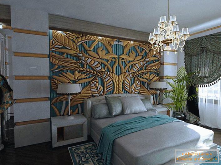 Un elegante ed esclusivo pannello in oro verde smeraldo sulla testata del letto è abbinato agli elementi decorativi della camera. Camera da letto nello stile di appartamenti art deco-reali in un normale appartamento.