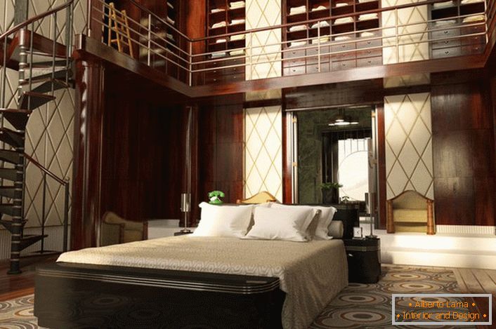 La camera da letto con soffitti alti è decorata in modo abbastanza efficace. Lo spazio è organizzato funzionalmente e semplicemente. Una scala a chiocciola conduce a un imponente guardaroba.