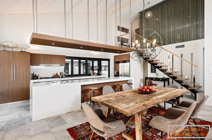 Un'elegante cucina in stile loft non è sovraccaricata di dettagli. Un funzionale e pratico set da cucina divide lo spazio in una zona da lavoro e da pranzo.