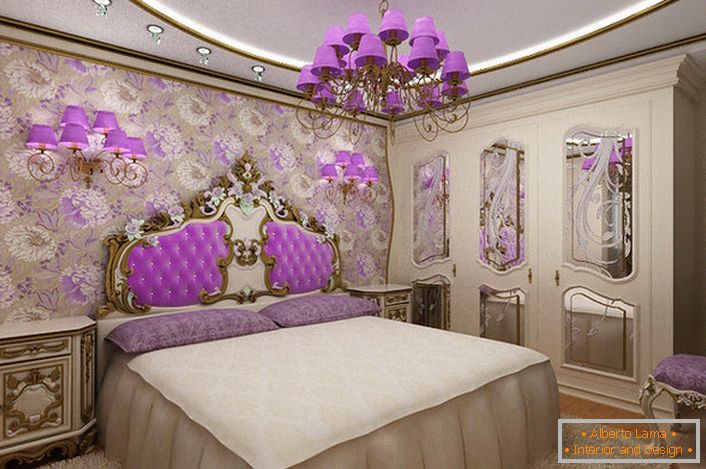 Elegante camera da letto barocca con un interessante accento sull'illuminazione. Lampadario e lampade da comodino con le stesse sfumature viola armoniosamente combinate con il rivestimento dello schienale nella testata del letto.