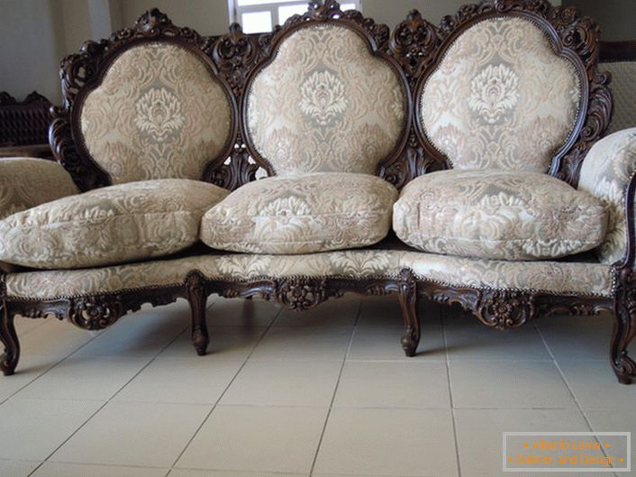 Bordatura decorata del retro, gambe intagliate, rivestimento tessile: la scelta perfetta per un soggiorno in stile barocco.