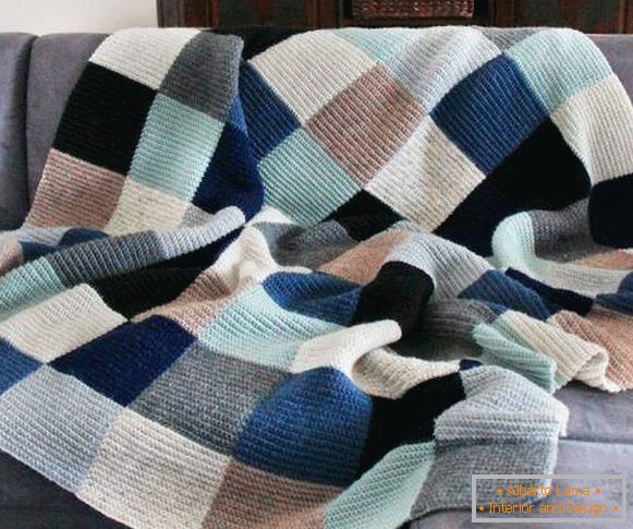 Bel plaid in maglia sul divano con le mani