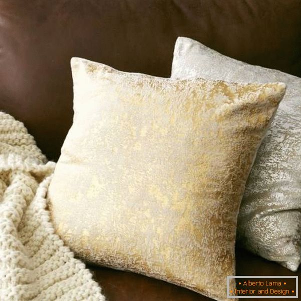 Cuscini brillanti e un plaid in maglia per il divano