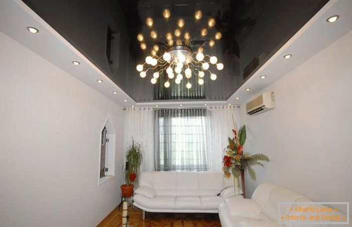 La lucentezza nera del soffitto sottolinea l'interno tenero e sgargiante del soggiorno.
