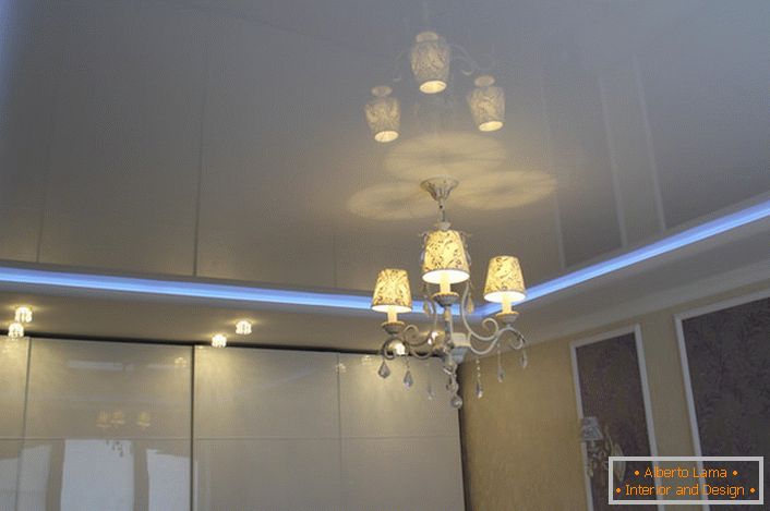 Striscia al neon, che divide i livelli del soffitto teso, - illuminazione insolita e spettacolare per la stanza.